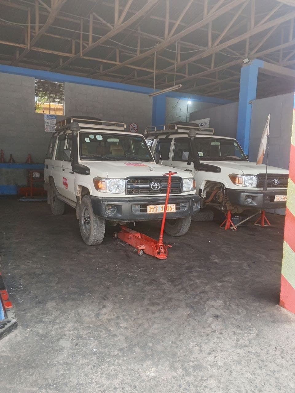 Indoor workshop with Toyota Land Cruisers on jack stands