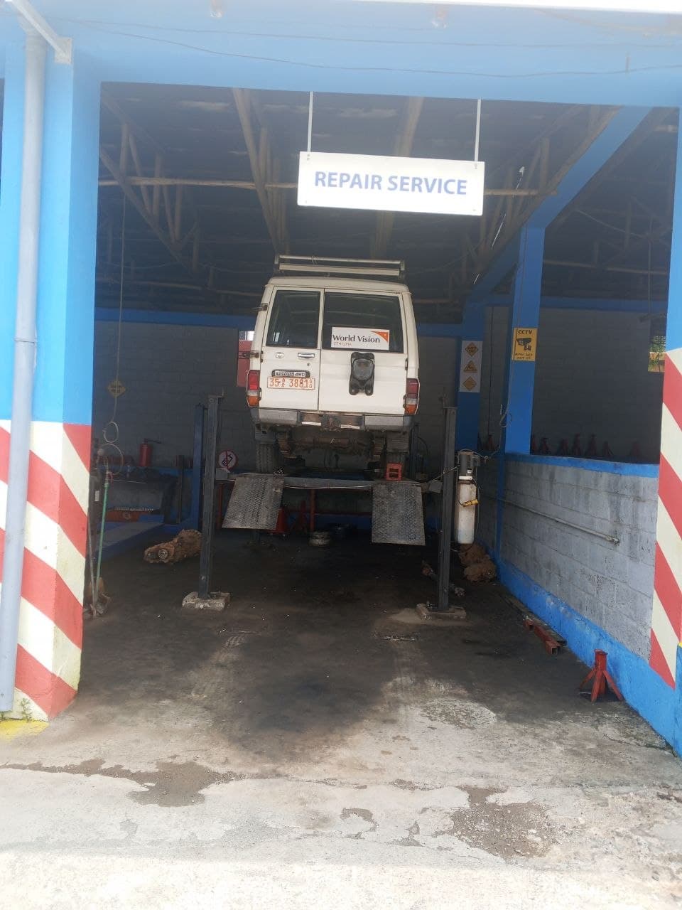 Repair service bay with vehicle on lift